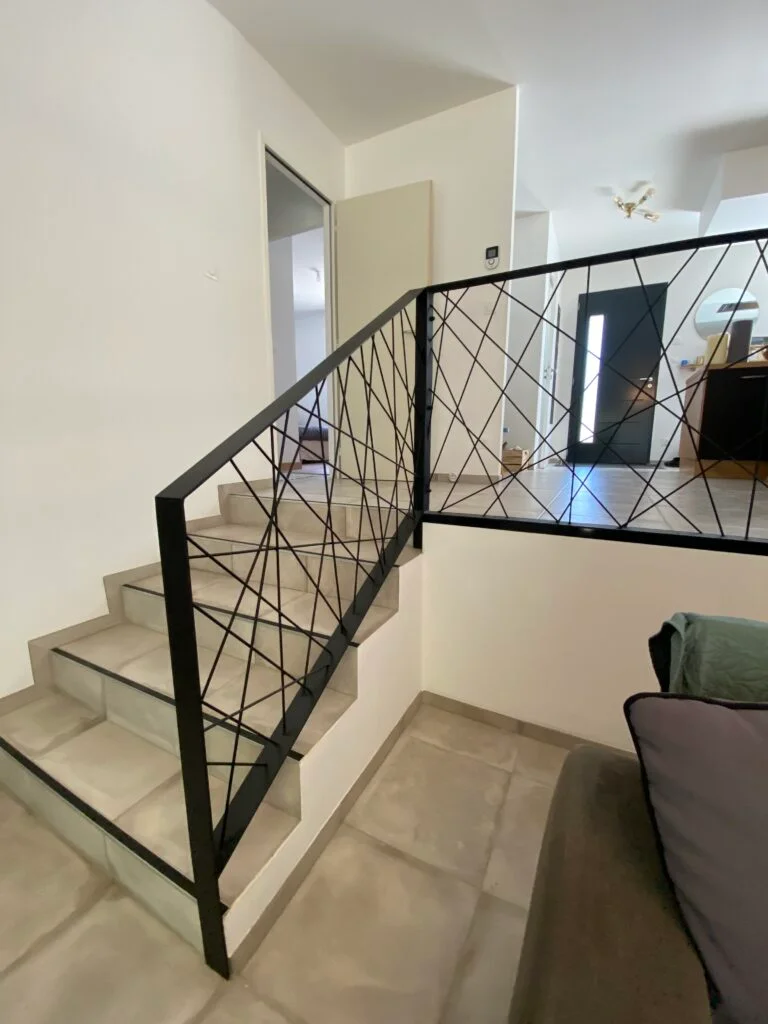 Garde-corps métal avec motif géométrique dans escalier