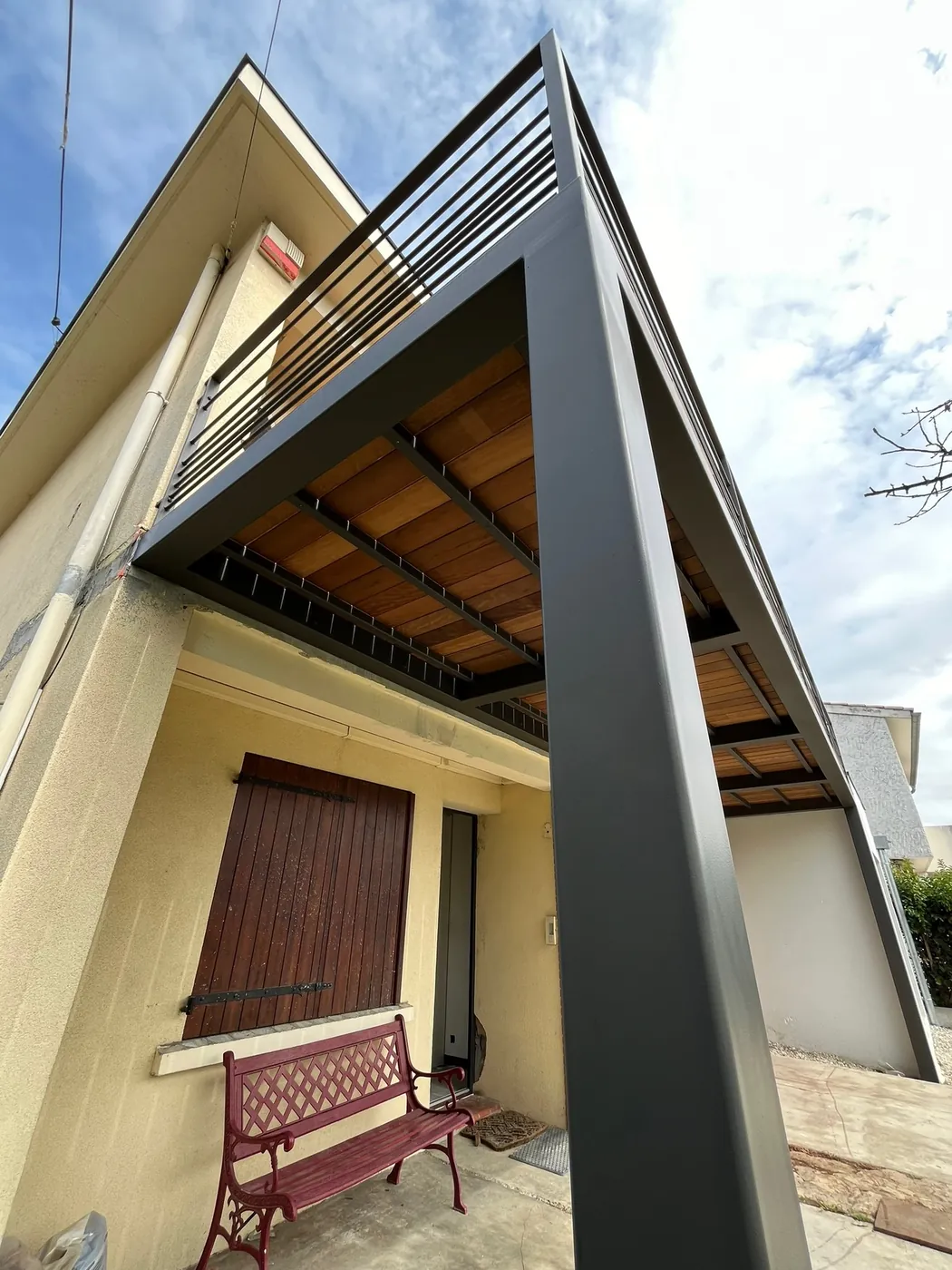 Auvent en structure métallique gris anthracite avec plafond en lames de bois, réalisation sur mesure ManufactureVB