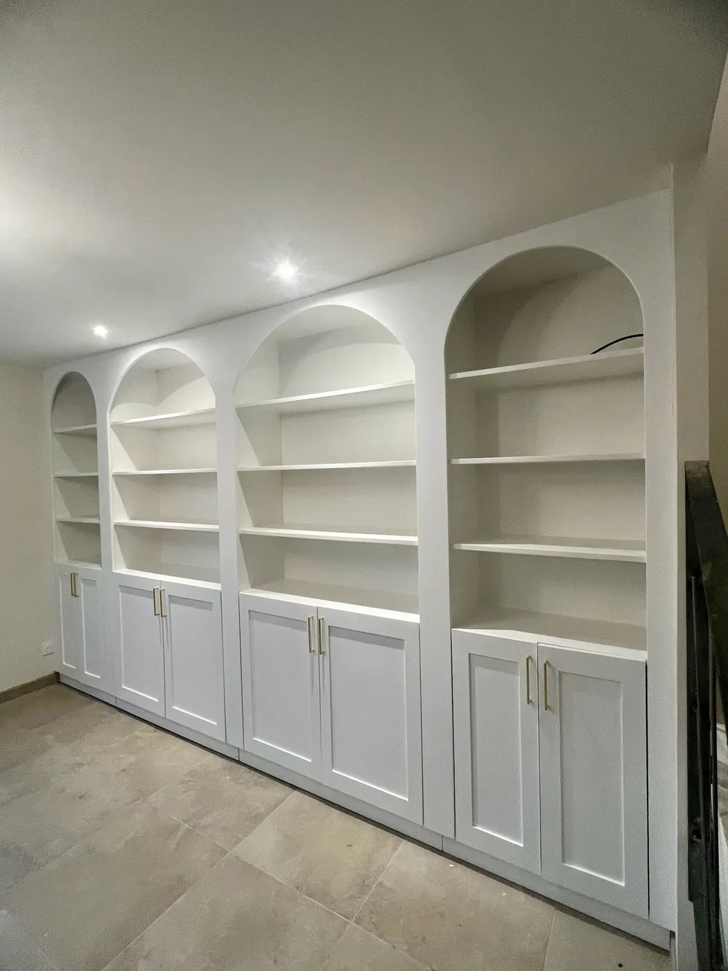 Bibliothèque sur mesure à niches arrondies et placards bas, agencement réalisé par ManufactureVB à Toulouse