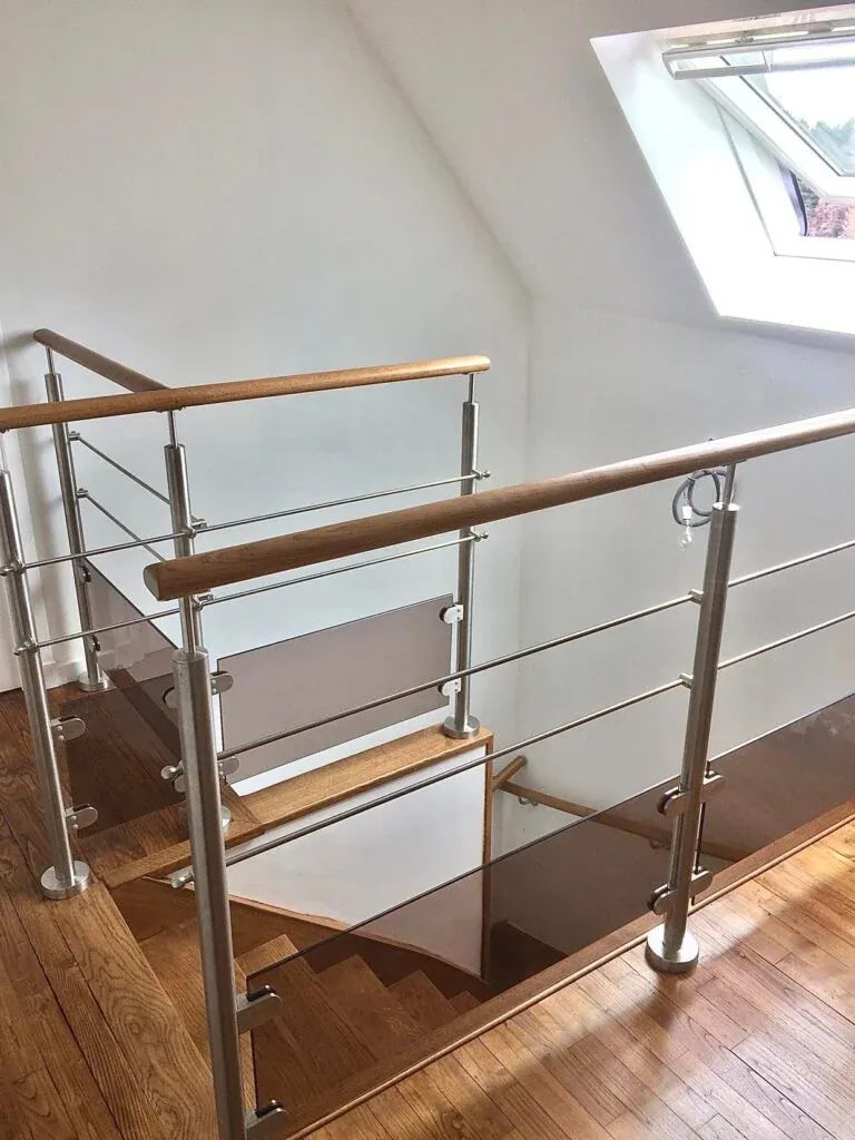 Garde-corps en inox brossé avec main courante en bois naturel dans un escalier intérieur contemporain, réalisation ManufactureVB