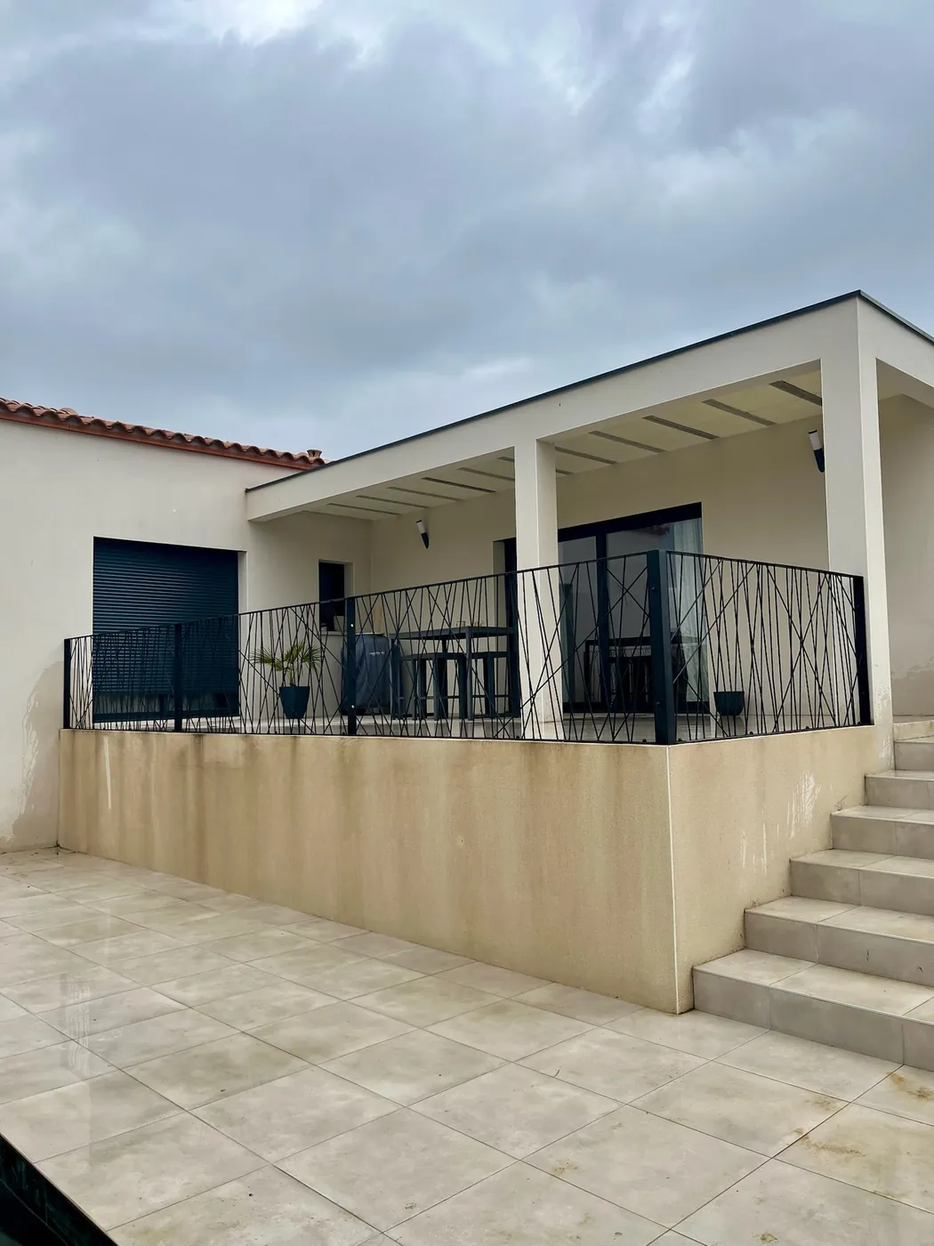 Garde-corps en acier noir à barres croisées sur la terrasse couverte d'une maison contemporaine près de Toulouse