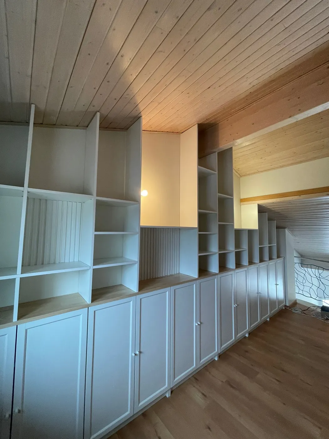 Rangements sur mesure sous comble avec placards et étagères, plafond en lambris bois, agencement ManufactureVB